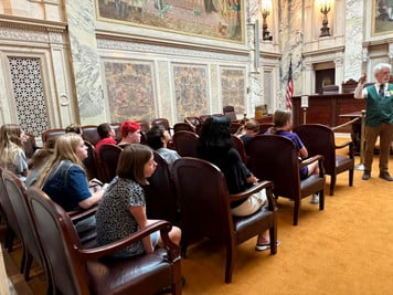 students listening to a presenter at WI State Capitol