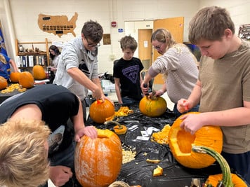 students carving pumpkins